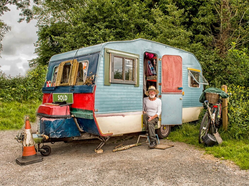 Photo Of A Man In White Long-sleeved Top on Blue And White Pop-up Camper